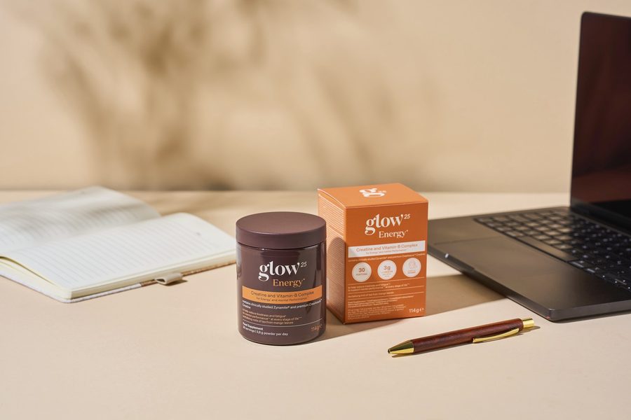 Glow25 Energy accanto a un taccuino e a un laptop sulla scrivania