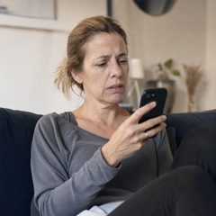 Femme relisant un message sur son téléphone