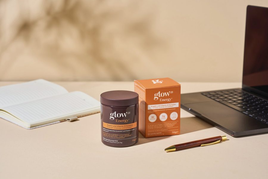 Glow25 Energy neben Notizbuch und Laptop am Schreibtisch